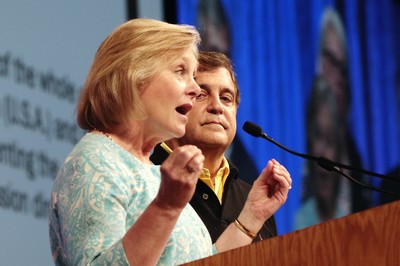 The Rev. Deborah Block, moderator of the All Agency Review Committee and the Rev. Mark Hostetter, monerator of The Way Forward Commission, speak to commissioners Sunday.